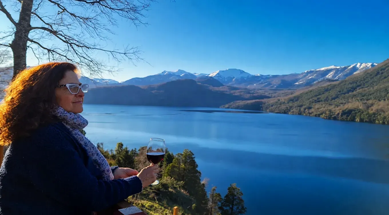 Woman enjoying a glass of Patagonian wine while overlooking a mountain lake