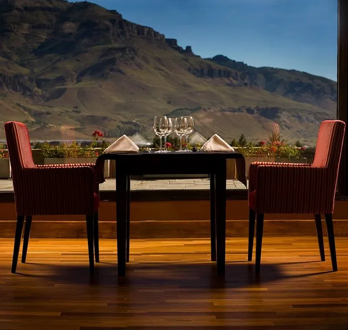 Mesa con copas y vista en Loi Suites Chapelco, un entorno premium para vivir el vino neuquino